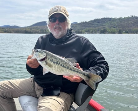 a man holding a fish on a boat
