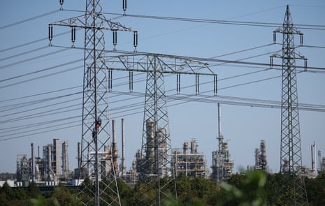Workers climb a high-voltage power line tower near the Leuna chemical refinery near Leuna, Germany, 13 August.