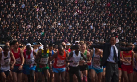 Spectators watch as runners line up at the start of the Pyongyang Marathon.