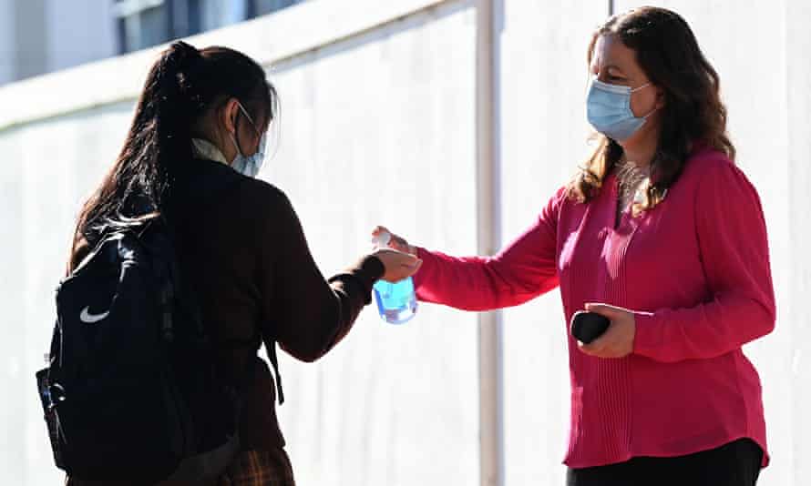 Teacher giving a student hand sanitiser
