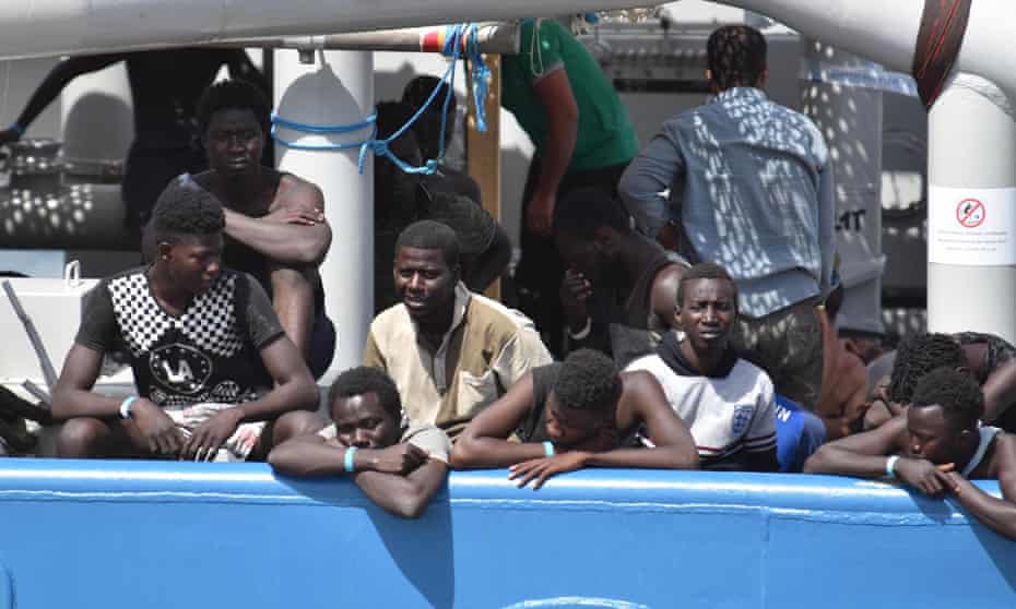 Migrants rescued in the Mediterranean Sea off Libya wait to disembark in Catania, Italy.