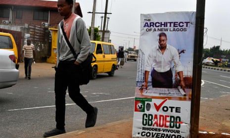 A man walks past a campaign banner for the Labour party candidate for governor, Gbadebo Rhodes-Vivour, in Lagos
