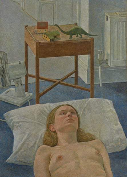 Image shows the painting Jacqueline With Still Life by Antony Williams. It features a person lying topless on the floor, their head on a pillow. In the background, next to a radiator, there is a dinosaur toy on a small wooden table alongside model houses. Nearby there is a desktop fan on the floor, which is dark blue.