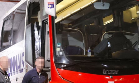 Broken windows visible on the Lyon team bus.