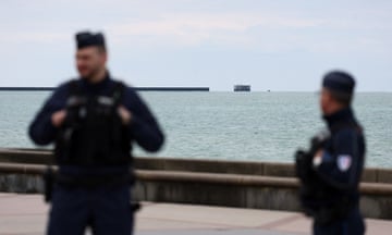 Police standing next to sea