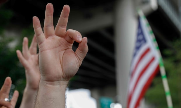 A US far-right demonstrator makes the OK hand gesture during a rally in Oregon.