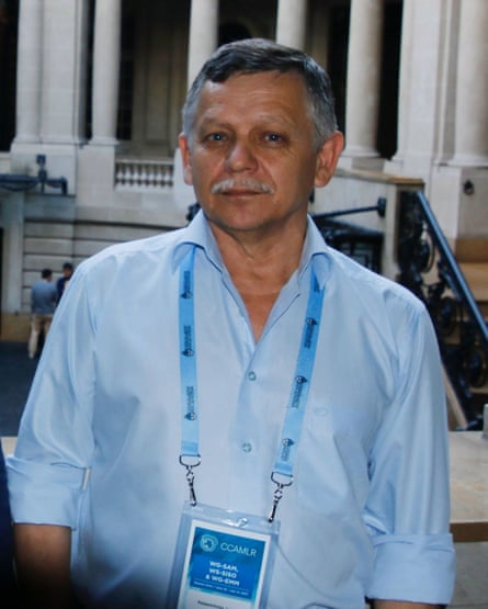 An older man posing for a picture before a neo-classical building with a lanyard marked CCAMLR