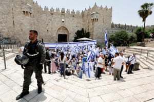 Jerusalem: Israeli border policeman stands guard as people carry national flags by the Damascus gate to Jerusalem’s Old city