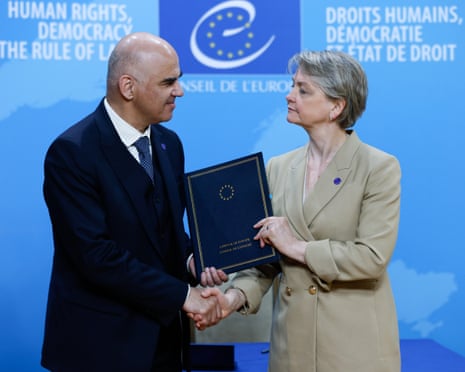 Secretary General Alain Berset and Foreign Secretary Yvette Cooper shake hands while holding a blue folder