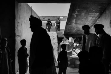 A group of people at the concrete entrance to a building, with a pile of boxes visible
