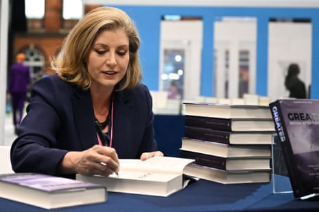 Penny Mordaunt, leader of the Commons, signing a copy of her book (published some time ago) at the Tory conference.