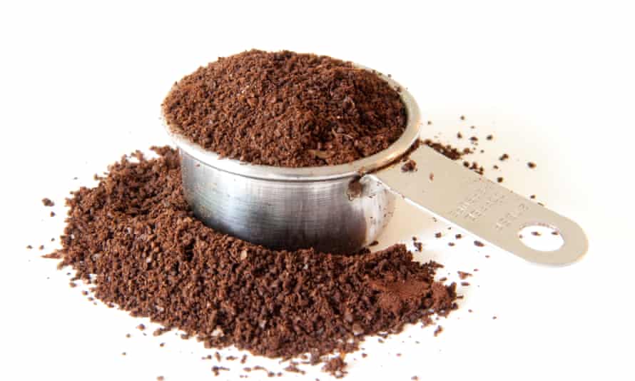 Ground coffee spilling out of a full coffee measure