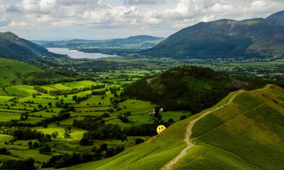 Montage of yellow smiley face against a backdrop of mountains and a lake