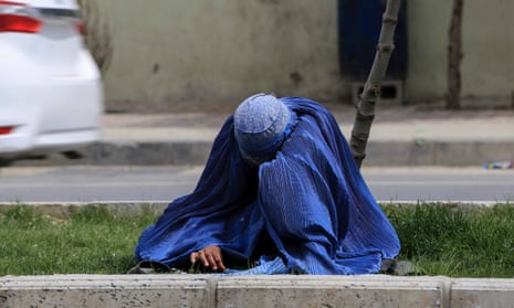 An Afghan woman begs on a road in Kabul, Afghanistan, 11 April 2022.
