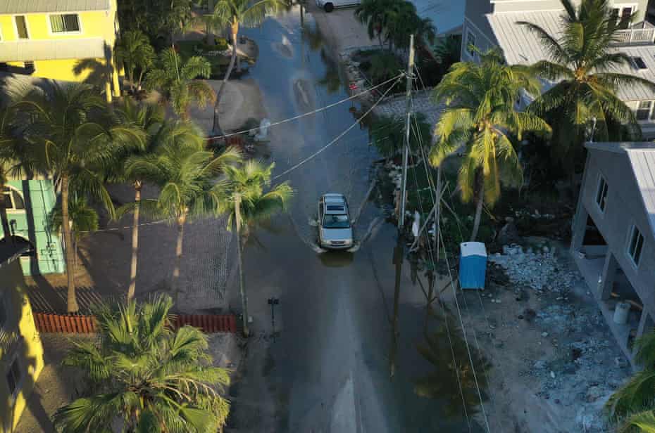 A car drives through a street flooded with ocean water in October 2019 in Key Largo.