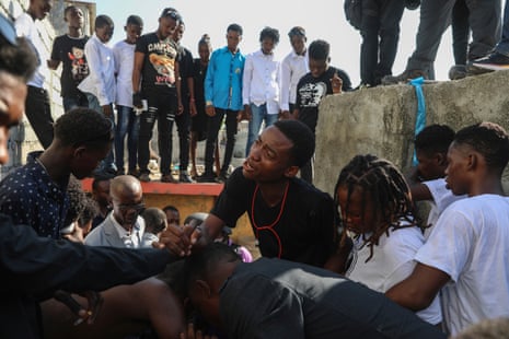 People grieve the death of a teenager who was killed by a stray bullet