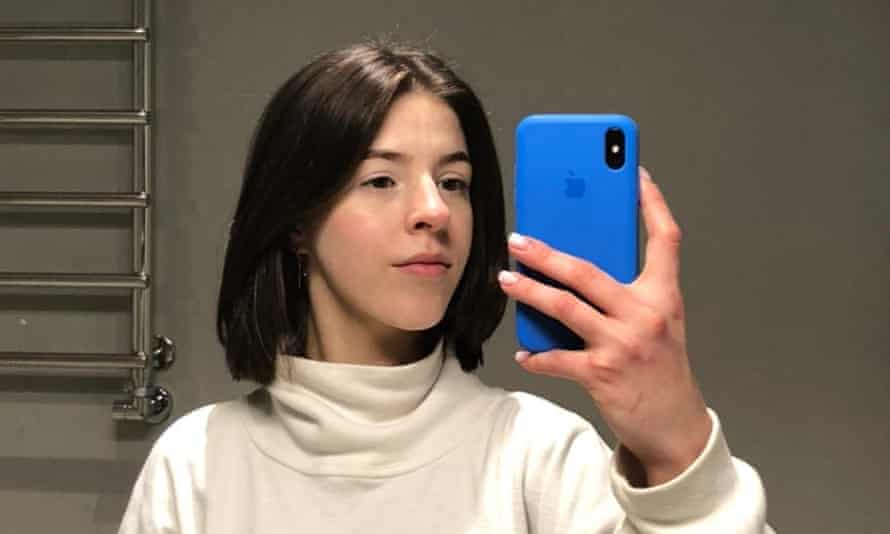 Diana Totok holding a phone with towel rail behind her