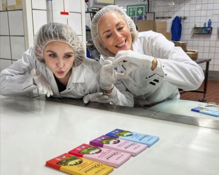 Two women wish bars of chocolate well.