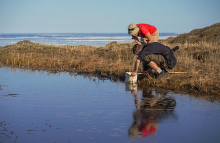 Two scientists take samples from the water’s edge