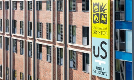 A large sign with the university logo on the side of a student housing block