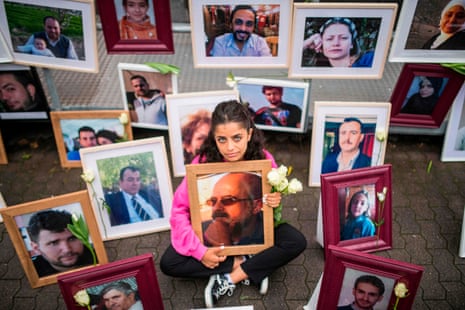 Wafa Mustafa sits among pictures of victims of the Syrian regime with a photograph of her father, Ali, during a protest outside the trial against two former Syrian intelligence officers accused of crimes against humanity, in Koblenz, Germany in June 2020.