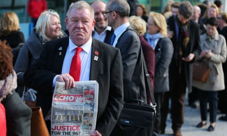 A man holds up a copy of the Liverpool Echo as relatives arrive at the inquest.