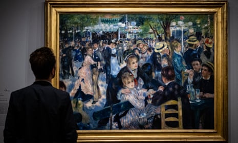 A visitor looks at the Renoir painting Bal du Moulin de la Galette