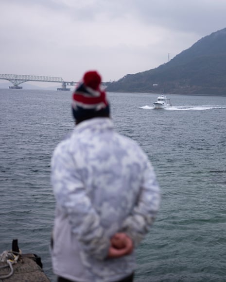 Hideya Yagi looking towards the sea as a boat approaches