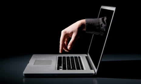 A hand reaching through a laptop