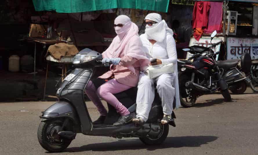 Motorcyclists are covered up to protect themselves against the scorching heat in Bhopal