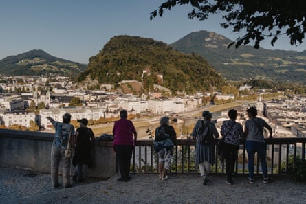People at a viewing point with a tree-covered hill in the distance