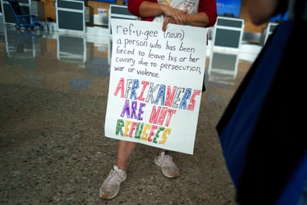 ‘Afrikaners are not refugees’ … A protester holds a placard at Dulles airport, Virginia.