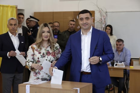 Presidential candidate and far-right party Alliance for the Union of Romanians (AUR) leader George Simion (R) casts his ballot with his wife, Ilinca Simion, (C) and banned candidate Calin Georgescu (L) during the second round of presidential elections, in Mogosoaia village, near Bucharest, Romania.