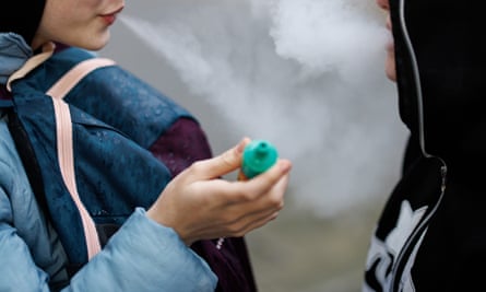 Two young people vaping.