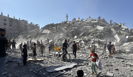 Palestinians in front of a pile of rubble