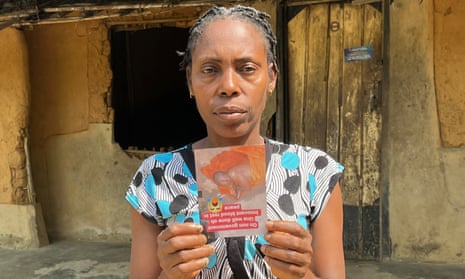 Mary holds a photo of her husband, Okon, who bled to death after being attacked by pirates.