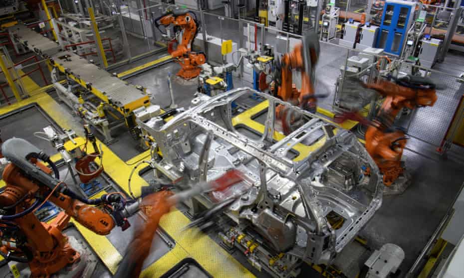 Robotic systems work on the chassis of a car during an automated stage of production at the Jaguar Land Rover factory in Solihull