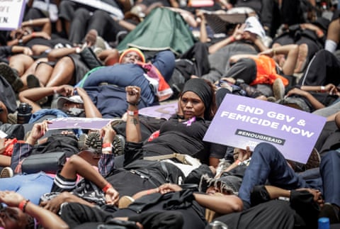 Protesters lie on the ground during the Women’s Nationwide Shutdown with a sign reading 'end gbv and femicide now'