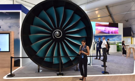 Un membre du personnel se tient à côté d'un modèle grandeur nature du nouveau moteur Rolls-Royce UltraFan au salon aéronautique international de Farnborough