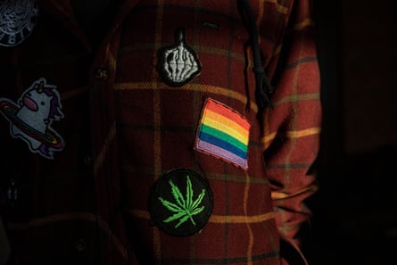 Closeup of a coat with a rainbow flag and other badges sewn on it. 