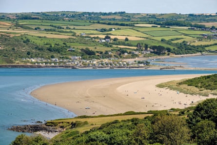 Sand dunes and sea with low hills behind