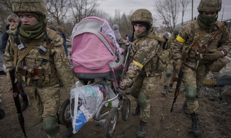 Ukrainian troops helped fleeing civilians cross the Irpin River after a bridge was destroyed by a Russian airstrike.