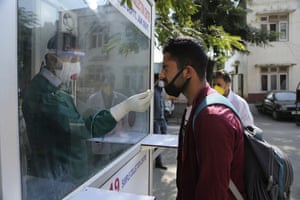 A health worker collects a nasal swab sample to test for Covid-19 at a government hospital in Jammu, India.