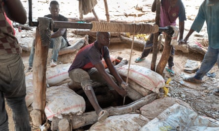 Miners haul sacks of rock to the surface