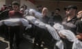 Palestinians holding shrouded bodies at Al-Aqsa hospital in Deir al-Balah, Gaza, on 10 July 2024.