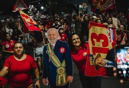 People dressed in red with a cardboard cut-out of Lula