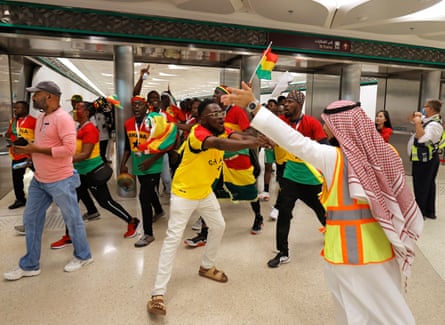 Singing and dancing Ghana fans are pointed in the right direction to the stadium by officials at Education City metro station before the Ghana v South Korea match.