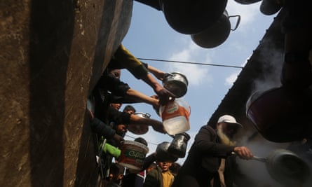 Palestinians queue to receive food in Rafah