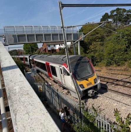 A Greater Anglia train on a section of track underneath a footbridge