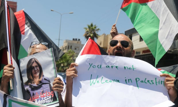 Protesters with a picture of Shireen Abu Aqleh and a sign reading ‘You are not welcome in Palestine’